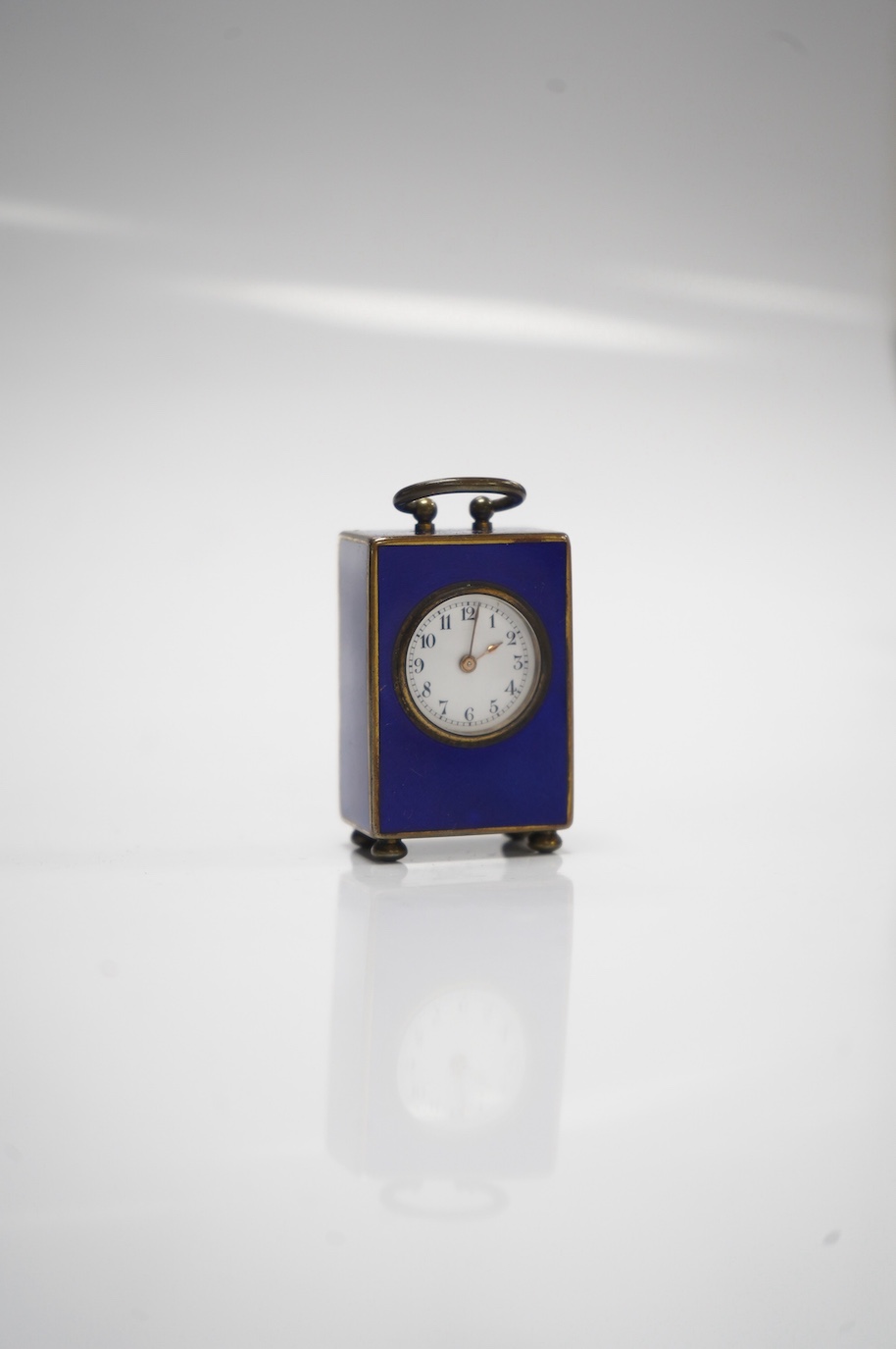 An early 20th century enamelled metal miniature carriage timepiece, cased, 6cm tall. Condition - case poor to fair, clock fair to good